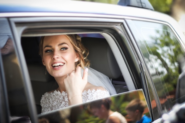 Glückliche Braut im Hochzeitsauto - Hochzeit mit Chauffeur München