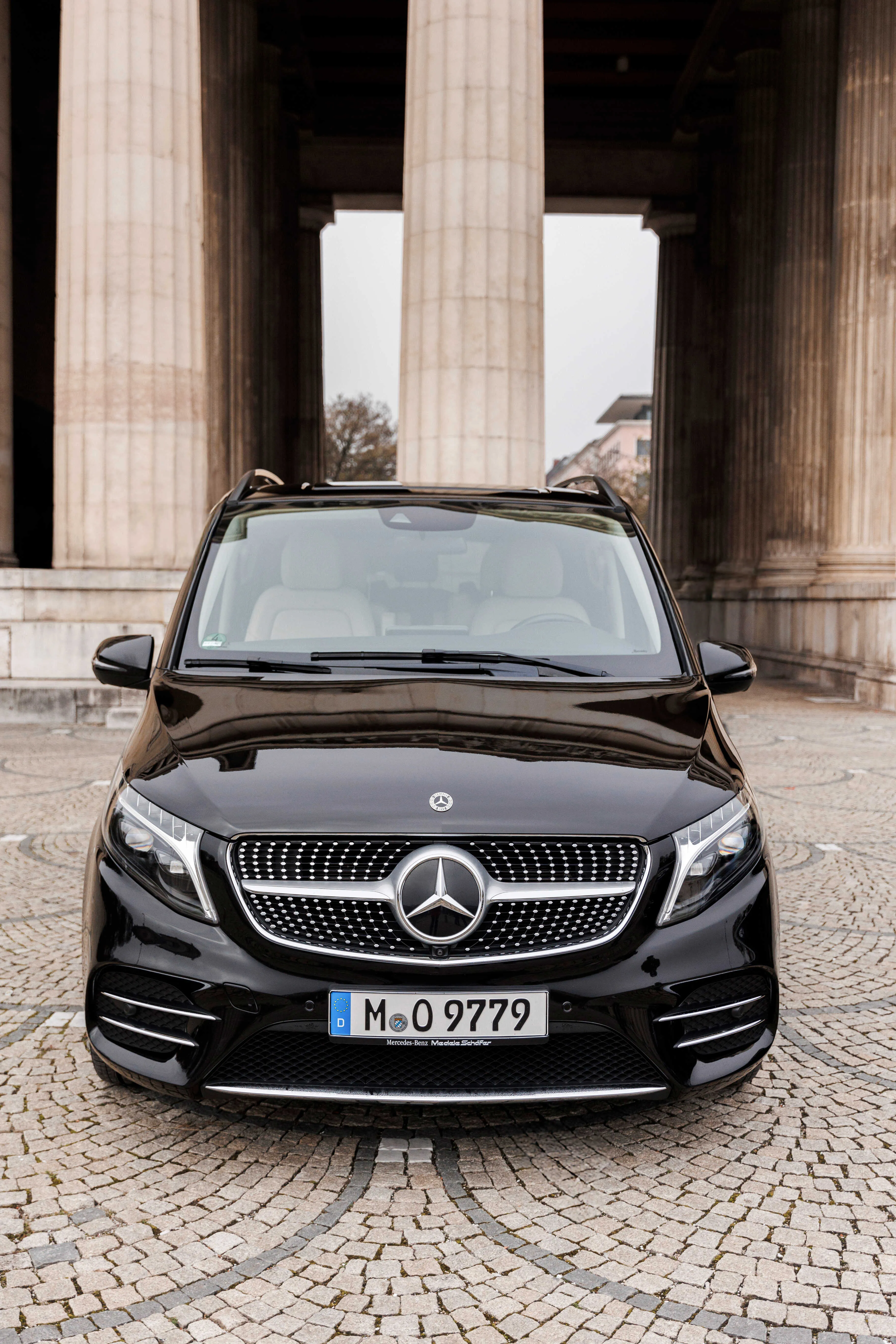 Schwarze Mercedes V-Klasse Frontansicht vor historischem Gebäude in München - Chauffeurservice Flughafentransfer